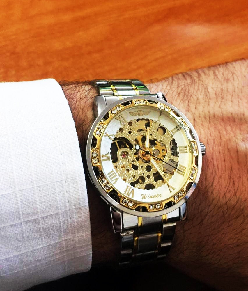 gold skeleton luxury watch on man's wrist