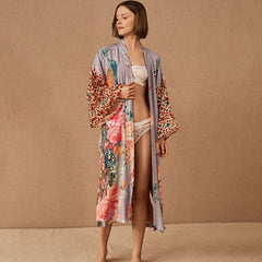 Woman wearing a floral kimono over a swimsuit on a beige background